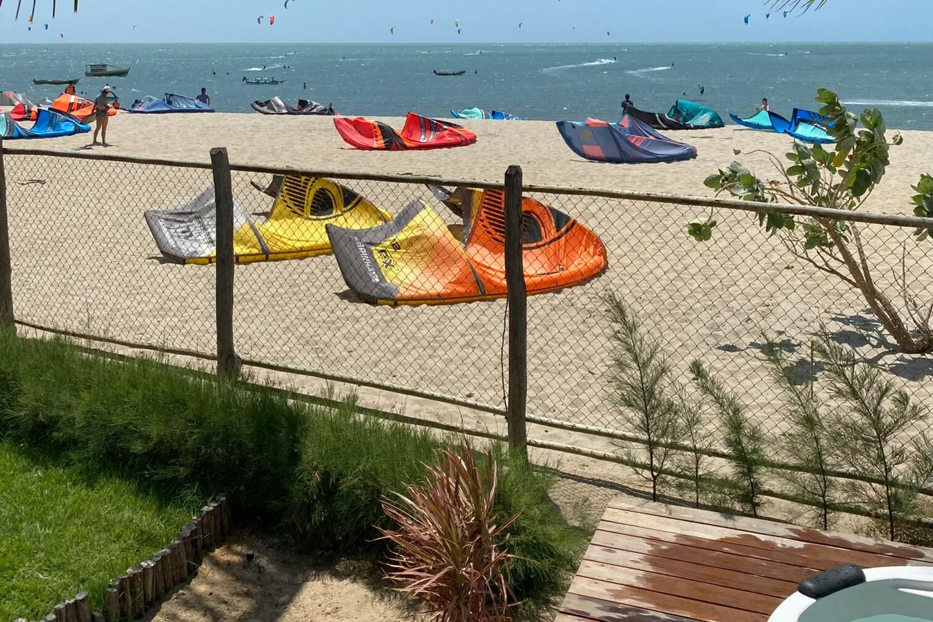 Kites preparados na areia e velejadores na água em Barra Grande, no Piauí
